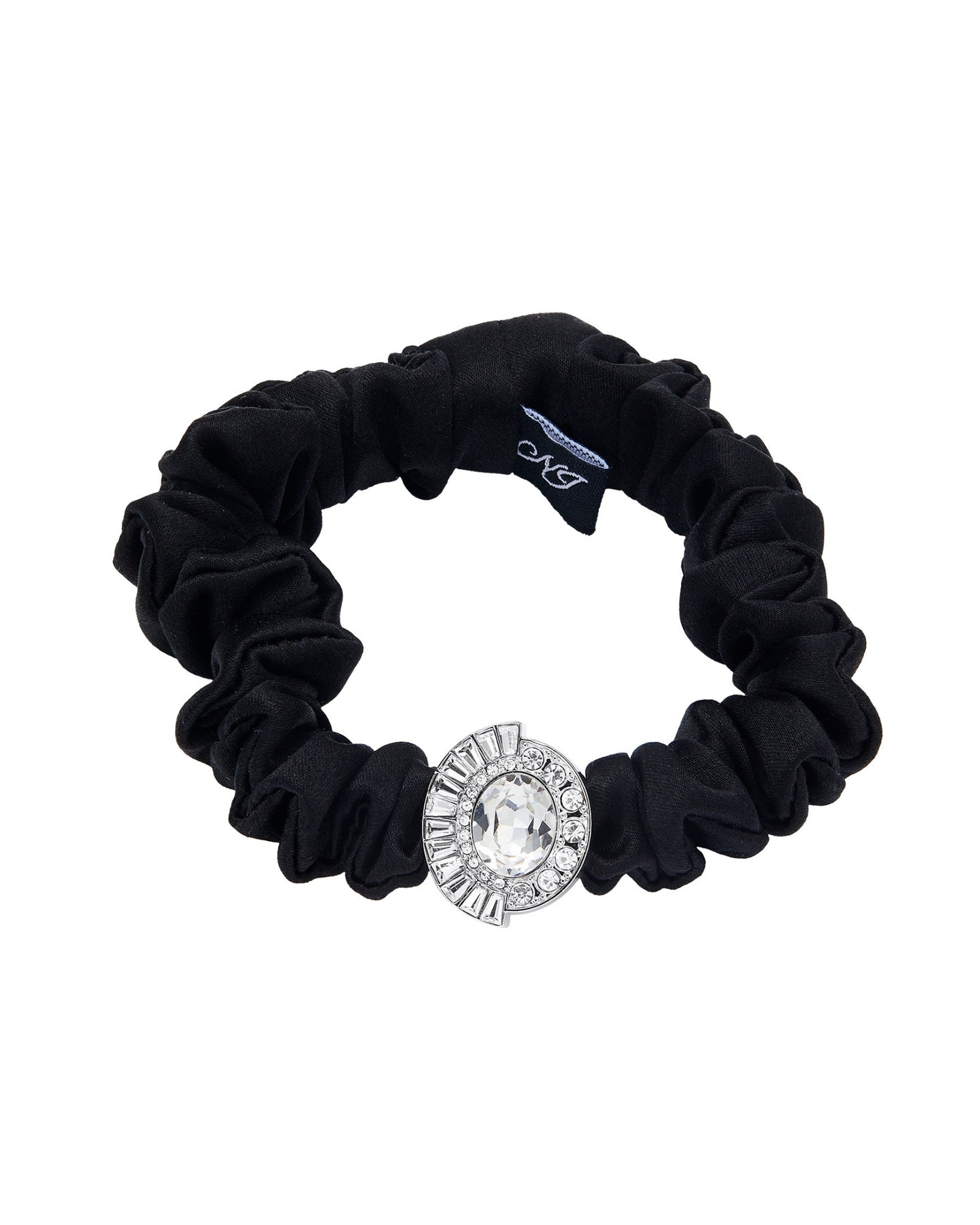 A black silk scrunchie accented with a silver diamond-shaped embellishment on a white background.