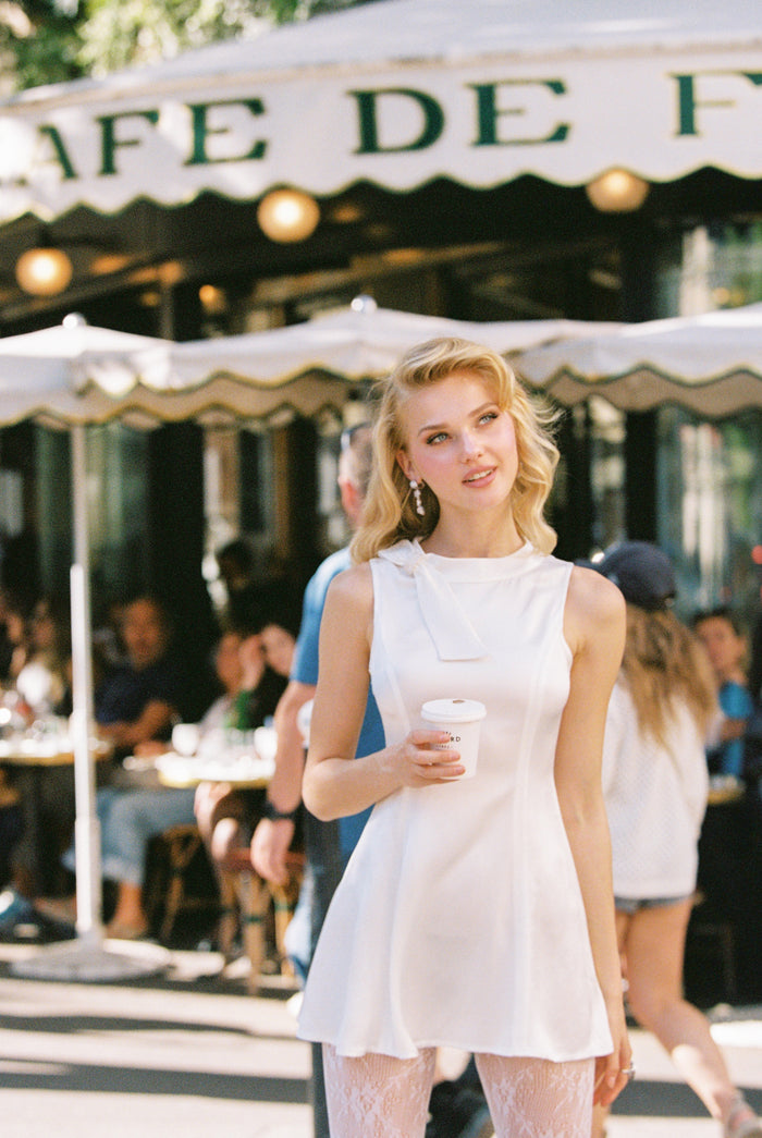 Lila white liquid satin A-line mini dress with diamond chain bow at neckline β birthday brunch dress