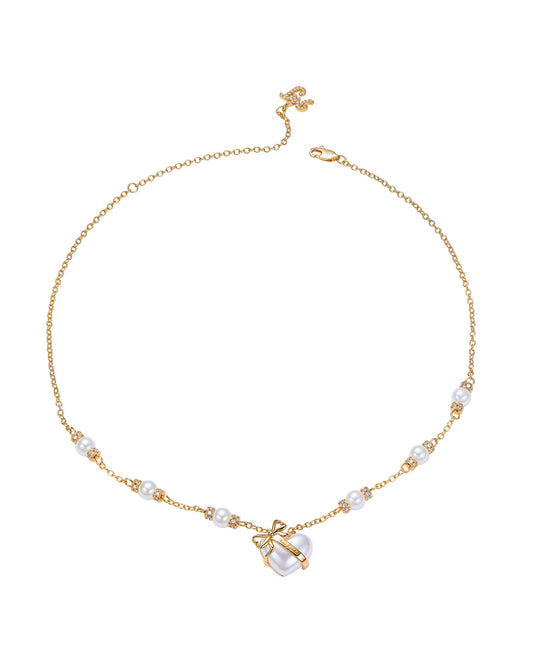 Gold necklace with pearl accents on a white background
