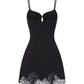 Black slip dress with lace trim on a white background