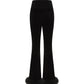 Black velvet pants with fur cuffs on a white background