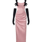 Pink evening gown with black bow straps and gloves on a white background