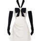 White dress with black bow and gloves on a white background
