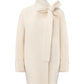 Cream-colored coat with a bow detail on a white background