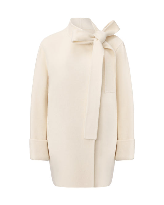 Cream-colored coat with a bow detail on a white background