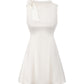 White sleeveless satin mini dress with a bow detail on a white background