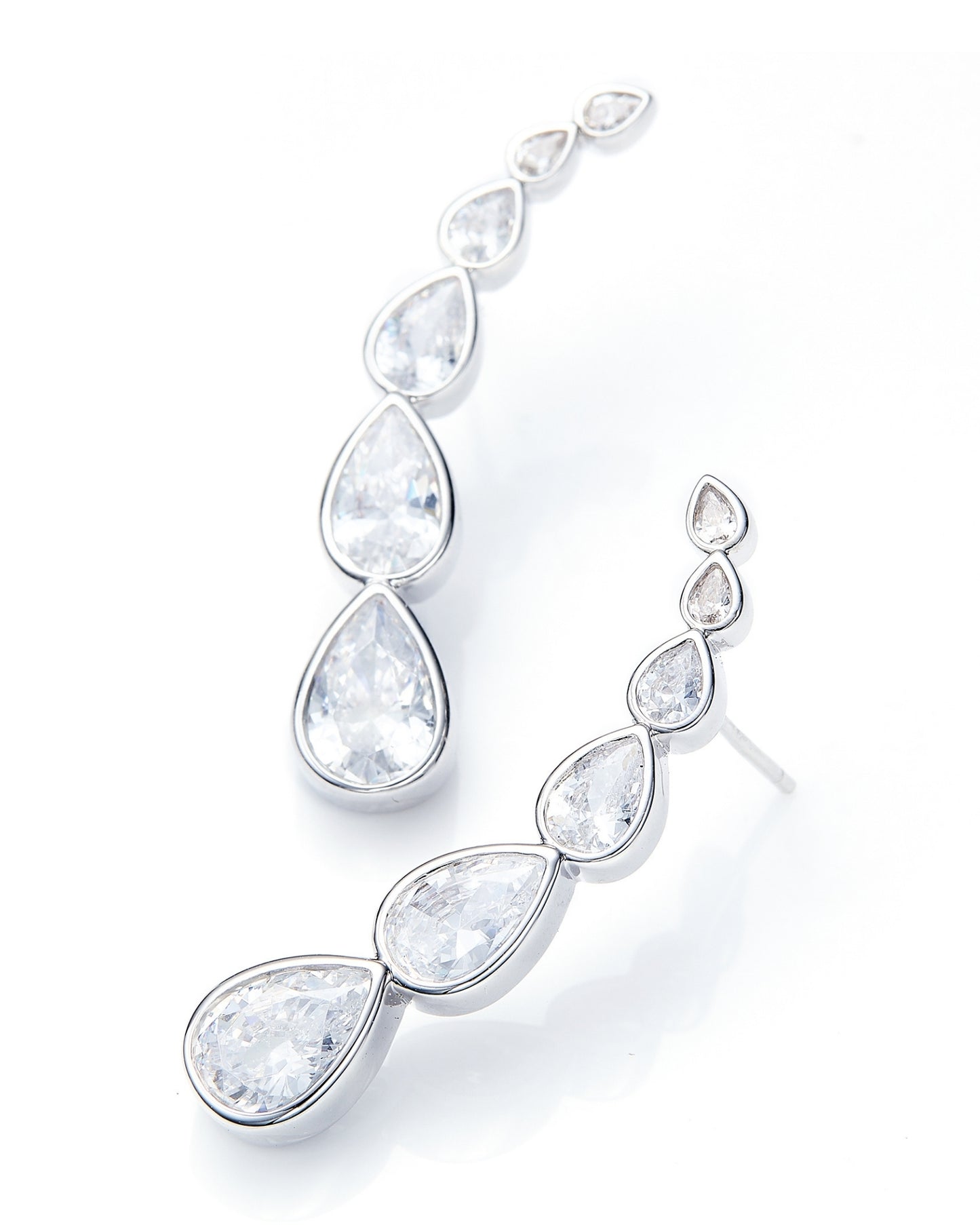 Silver earrings with clear teardrop-shaped gemstones on a white background