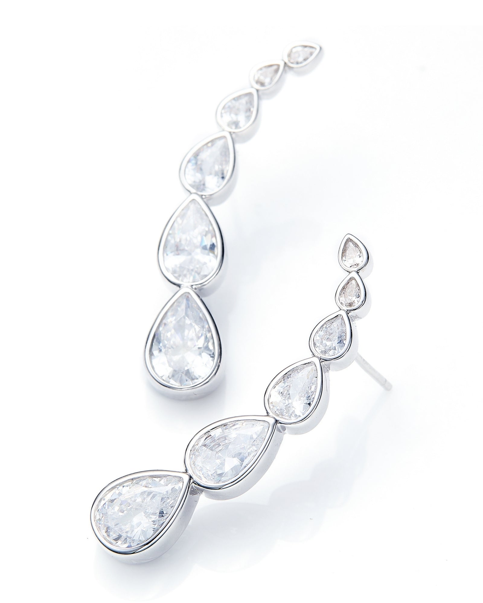 Silver earrings with clear teardrop-shaped gemstones on a white background