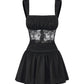 Black satin dress with lace detailing on a white background