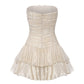 Gold strapless dress with ruffled layers on a white background