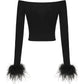 Black off-shoulder top with feathered cuffs on a white background