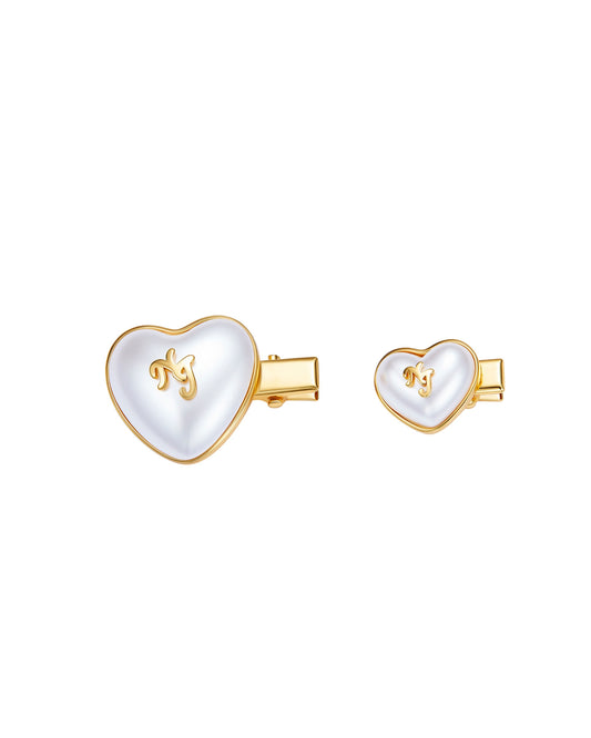 Heart-shaped hair pins with gold and white finish on a white background