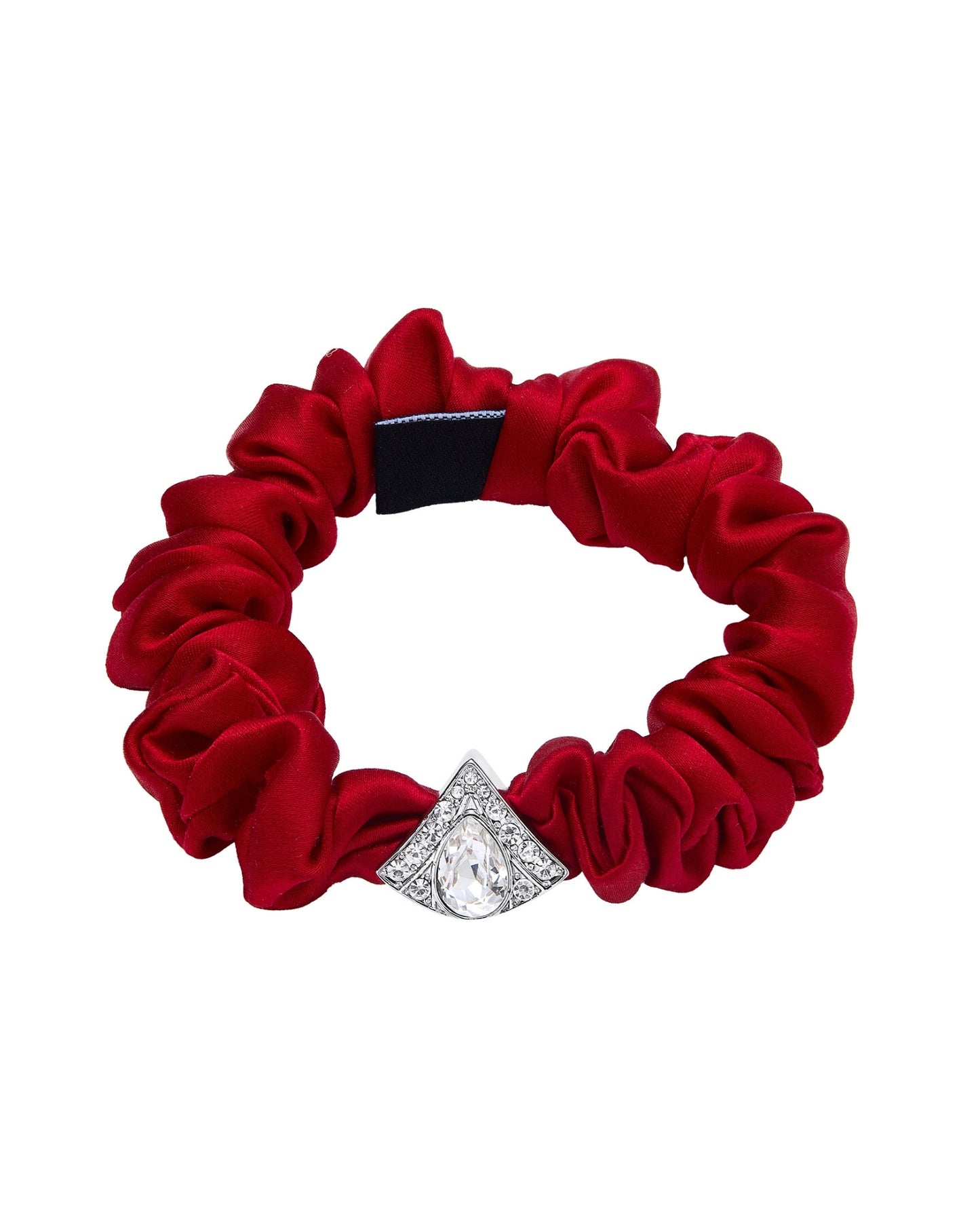 A red silk scrunchie accented with a silver diamond-shaped embellishment on a white background.