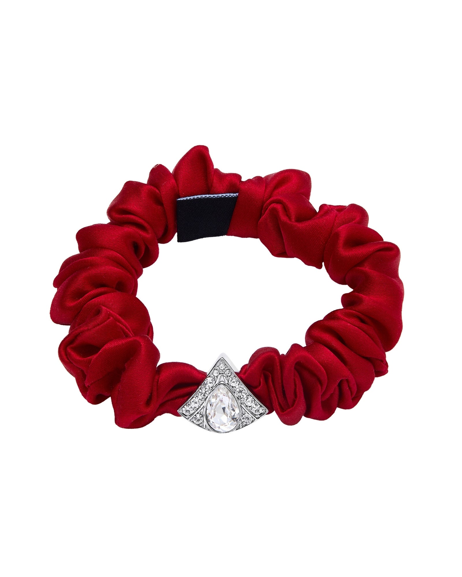 A red silk scrunchie accented with a silver diamond-shaped embellishment on a white background.