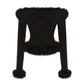 Black knitted top with fur trim on a white background