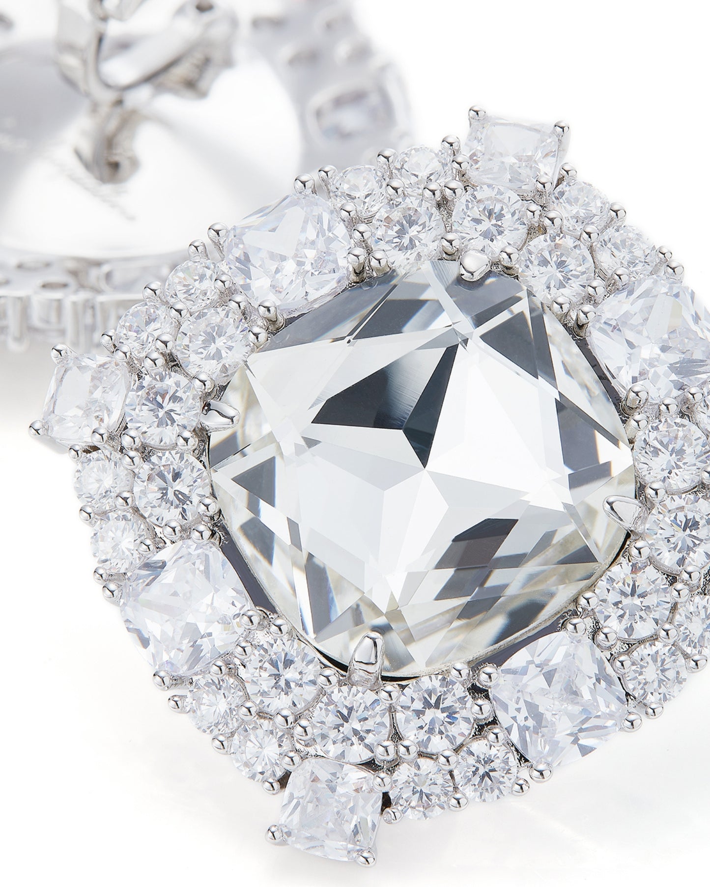 Diamond earrings with a large central diamond and smaller diamonds around on a white background