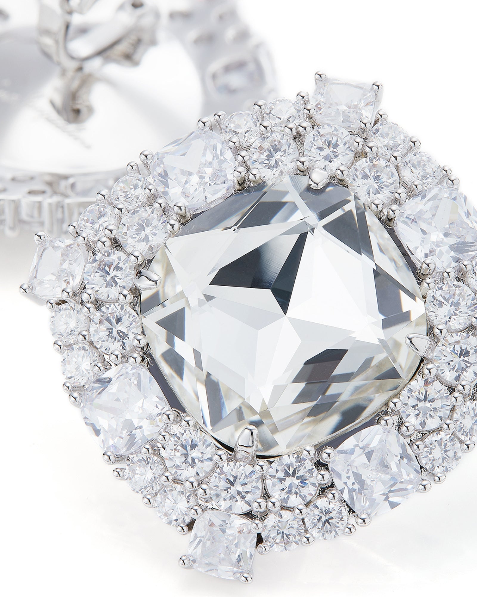 Diamond earrings with a large central diamond and smaller diamonds around on a white background