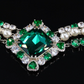 Crystal-embellished diamond shape necklace with green emerald accents.