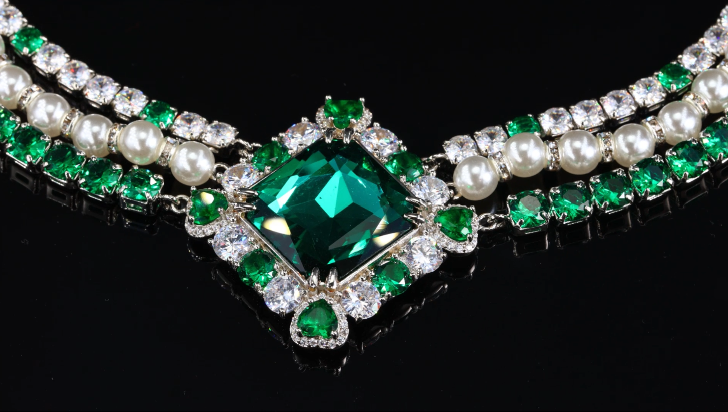 Crystal-embellished diamond shape necklace with green emerald accents.