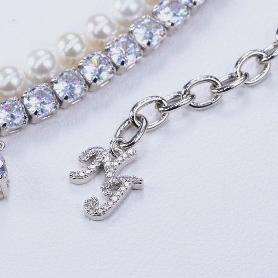 silver chain with layered detailing, and diamond teardrop drip necklace