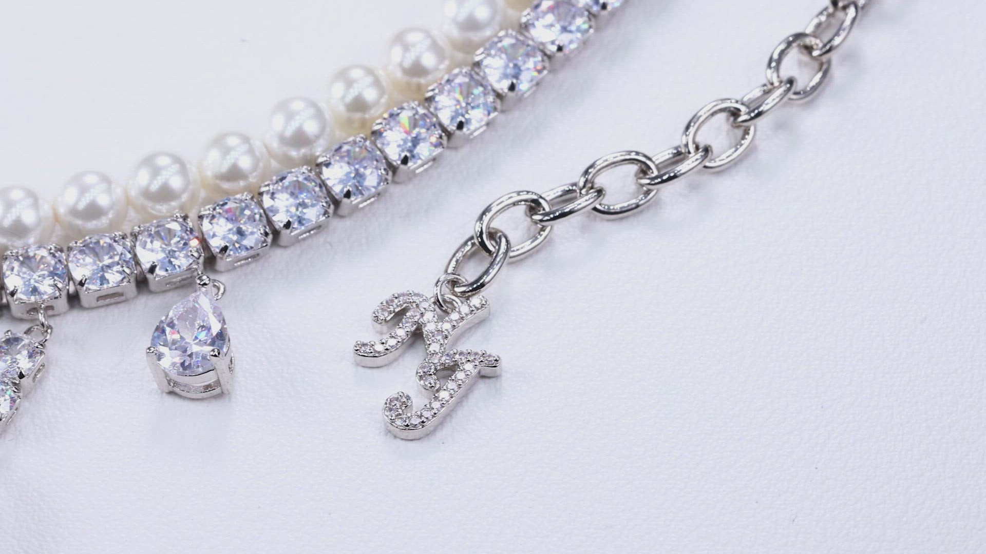 silver chain with layered detailing, and diamond teardrop drip necklace